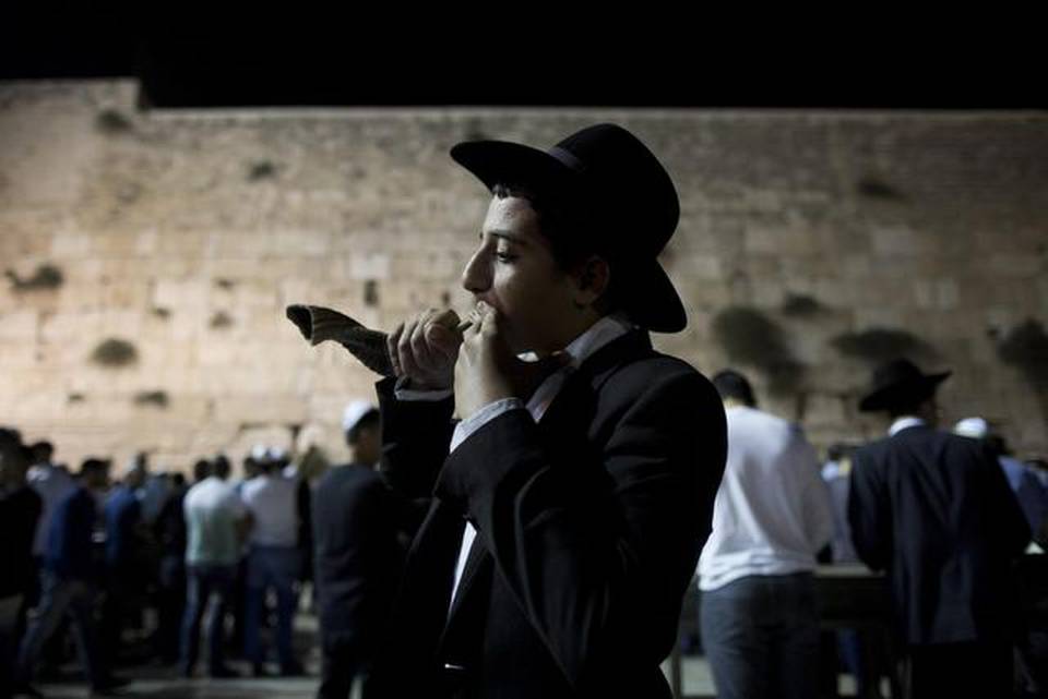 Un joven judío ultraortodoxo sopla un "shofar" durante la noche para los perdones (Selichot) en el Muro Oeste, el lugar más sagrado en el judaísmo, en la antigua ciudad de Jerusalén (Israel) hoy, miércoles 24 de septiembre de 2014, en el marco de la celebración del Nuevo Año Judío (Rosh Hashanah) 