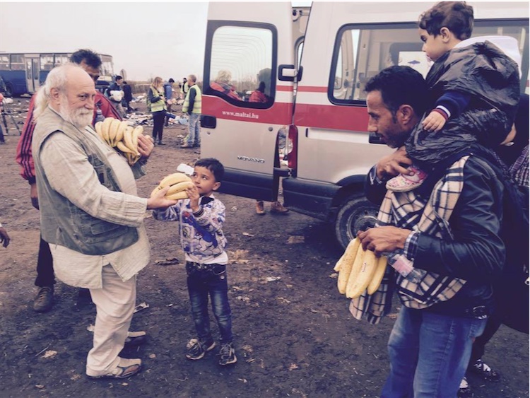 Un miembro Congregacional de ISKCON da un cacho de bananas a los exiliados en la frontera