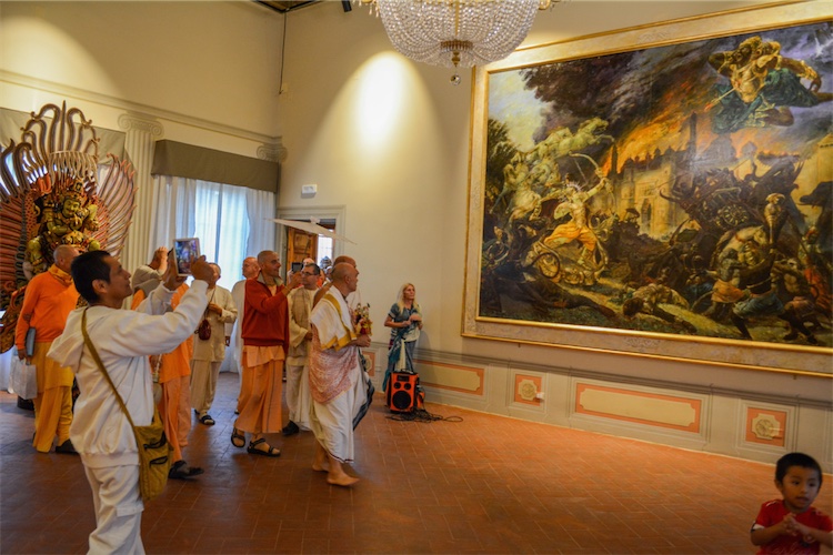 Invitados obserban una dramática pintura del Señor Rama matando al demonio Ravana